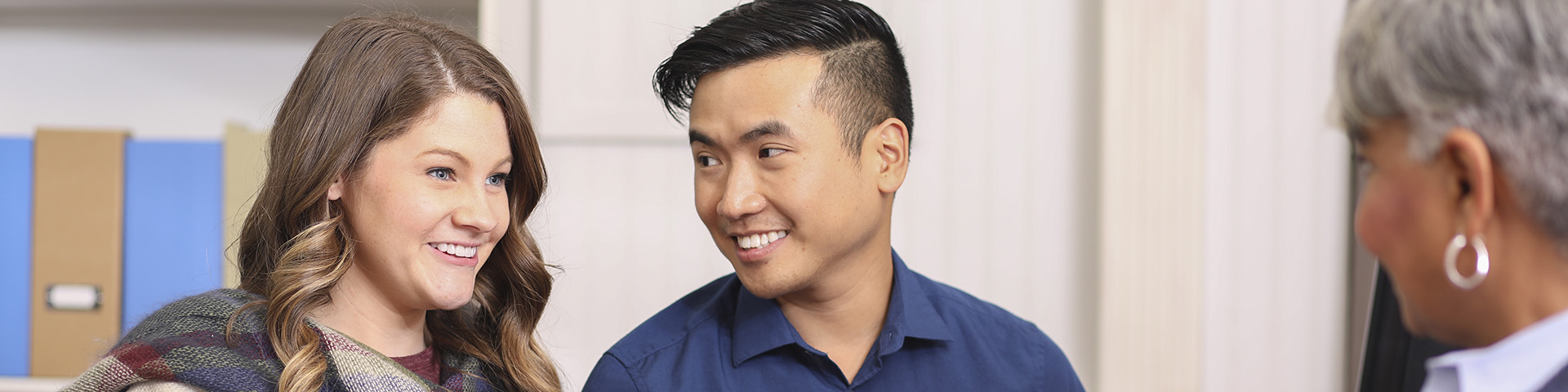 couple smiling and sitting across from therapist