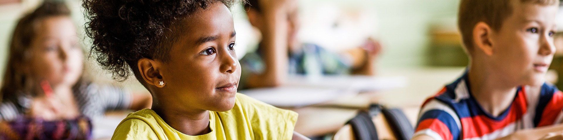 students sitting in class paying attention to teacher